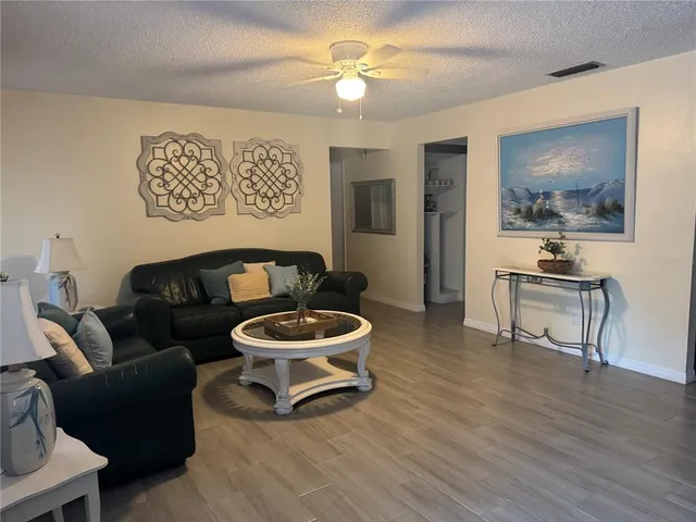 a living room with furniture and a wooden floor