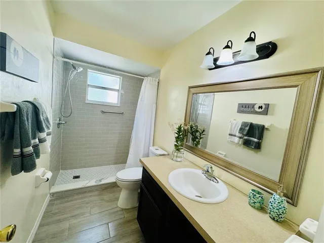 a bathroom with a granite countertop sink toilet and shower