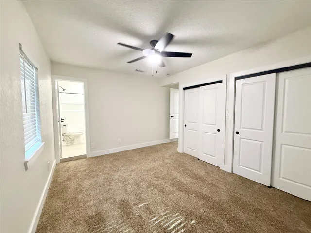 a view of an empty room and a ceiling fan