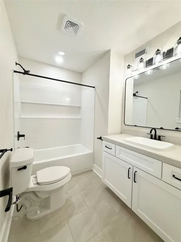 a bathroom with a sink a toilet a mirror and a bathtub