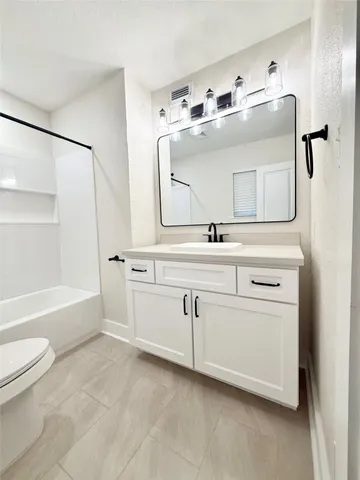 a bathroom with a double vanity sink toilet mirror and bathtub