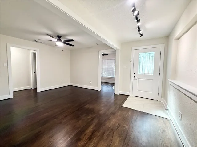 a view of an empty room with wooden floor
