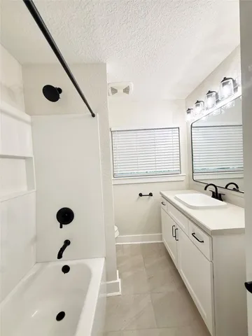 a bathroom with a tub sink and mirror