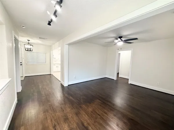 a view of an empty room with wooden floor