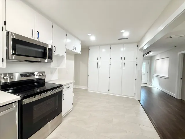 a kitchen with stainless steel appliances kitchen island granite countertop a stove and a sink