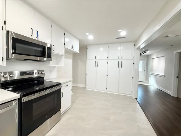 a kitchen with stainless steel appliances kitchen island granite countertop a stove and a sink