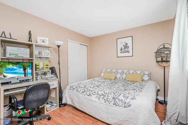 a bedroom with a bed a computer on desk and a chair
