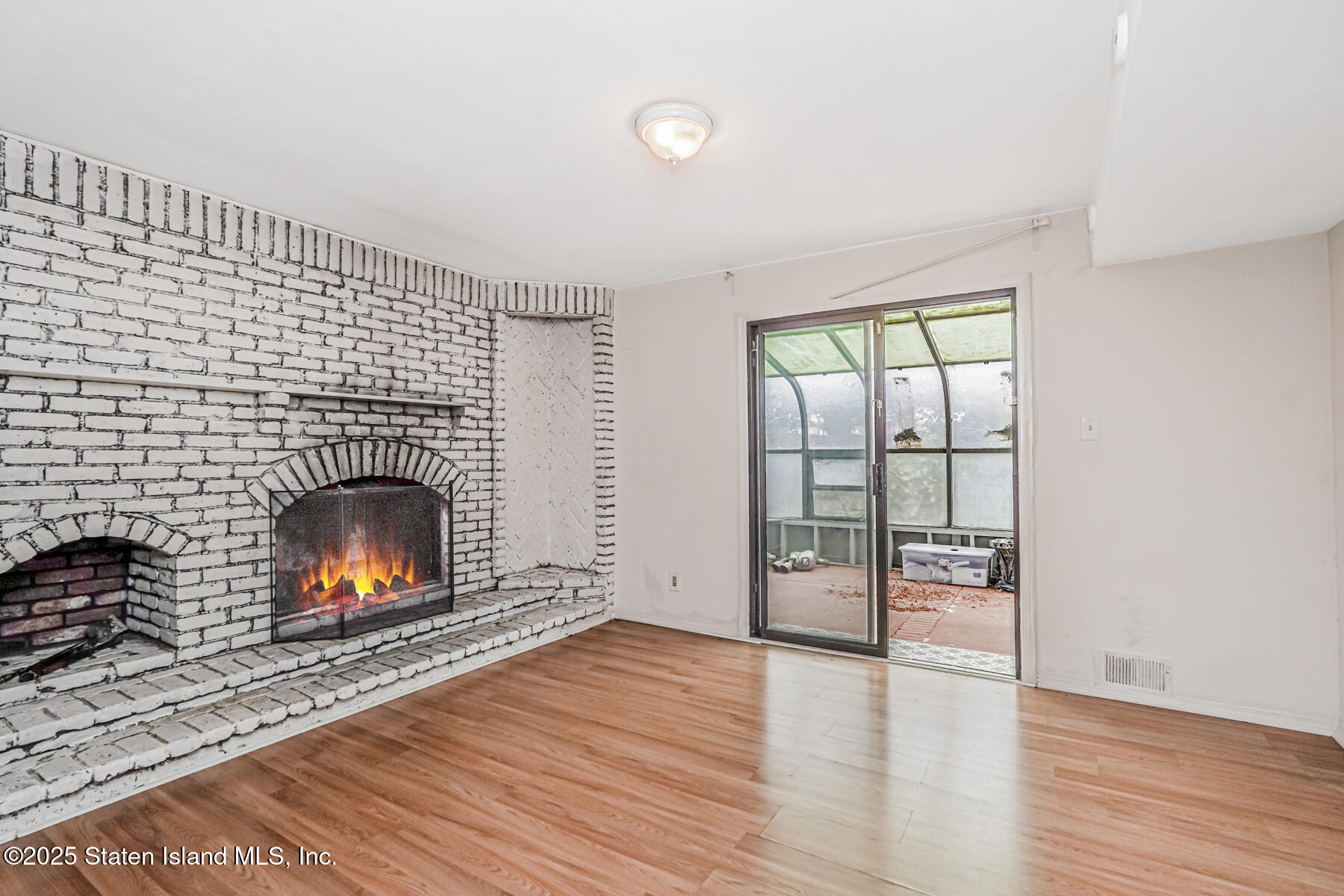 45 Sommer Avenue Staten Island, NY 10314 - Photo 19 of 31 an empty room with wooden floor fireplace and windows