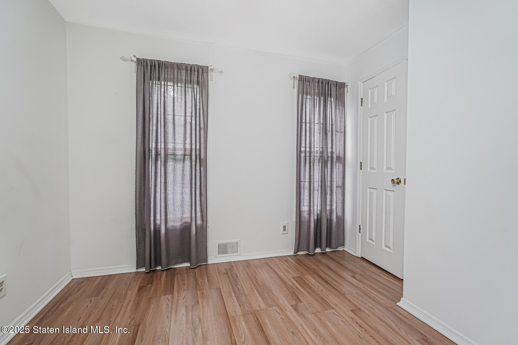 45 Sommer Avenue Staten Island, NY 10314 - Photo 23 of 31 an empty room with wooden floor and a bathroom