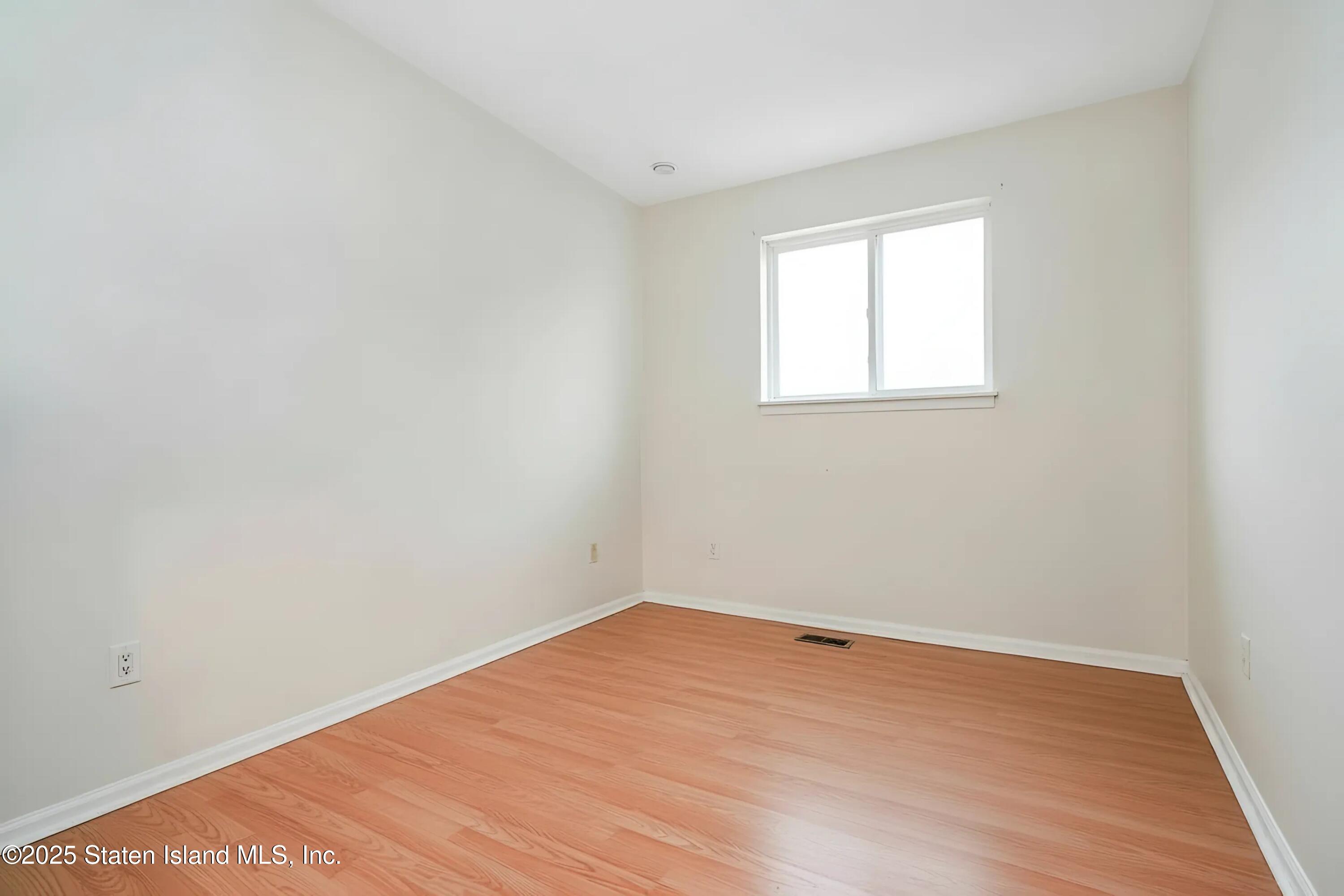 45 Sommer Avenue Staten Island, NY 10314 - Photo 25 of 31 an empty room with wooden floor and windows