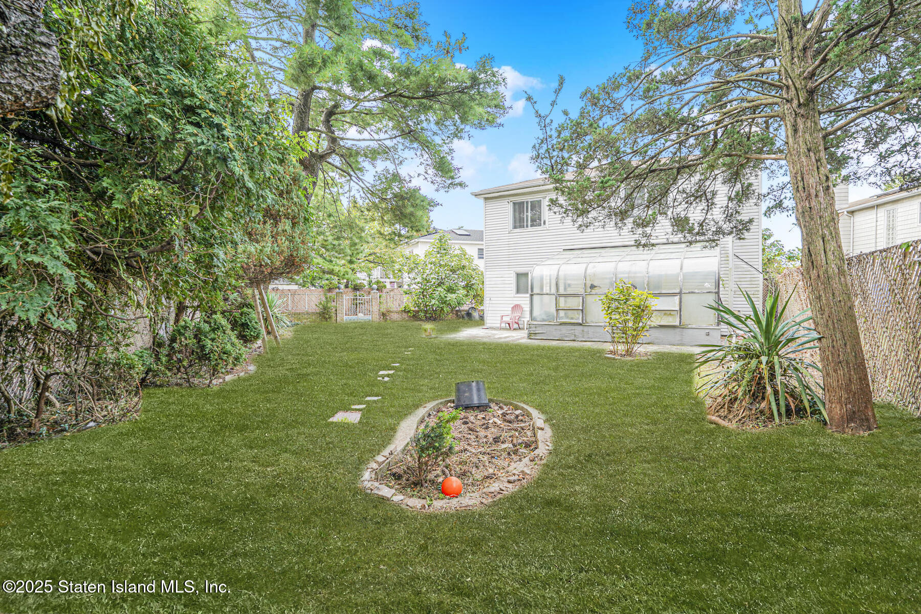 45 Sommer Avenue Staten Island, NY 10314 - Photo 26 of 31 a view of a white house with a big yard and potted plants and large trees