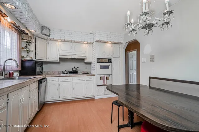a kitchen with stainless steel appliances granite countertop a sink dishwasher and stove with wooden floor