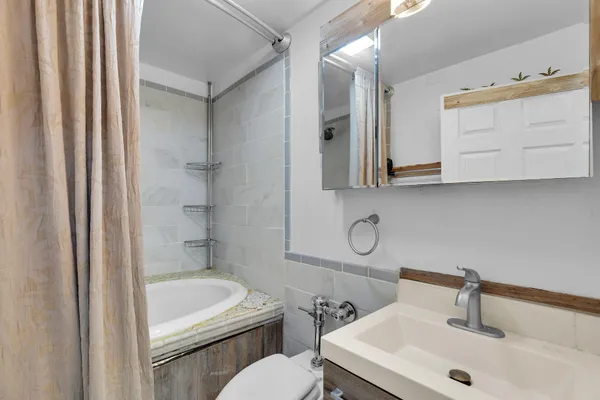 a bathroom with a sink a toilet and shower