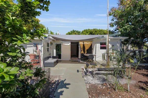 a view of a house with backyard sitting area and garden