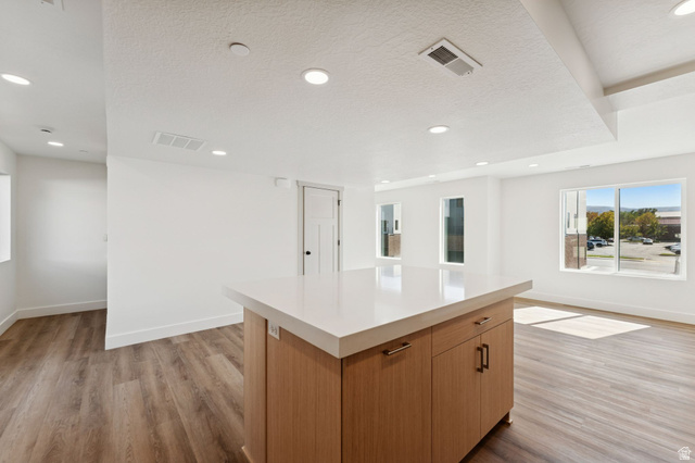 252 North Main Street Bountiful, UT 84010 - Photo 9 of 34 Kitchen with a center island, light wood-style flooring, recessed lighting, a textured ceiling, and wood finish cabinetry