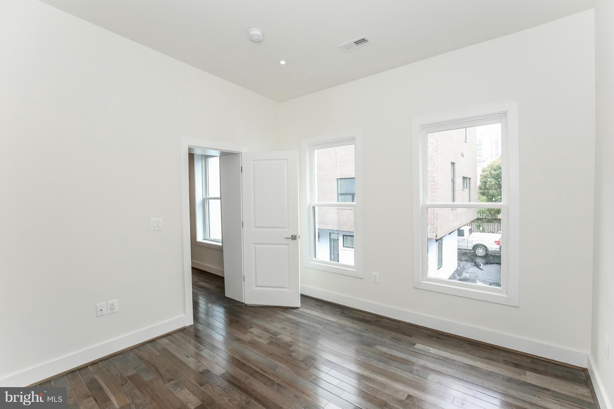462 Ridge Street Northwest, Unit 3 Washington, DC 20001 - Photo 14 of 20 a view of an empty room with wooden floor and a window