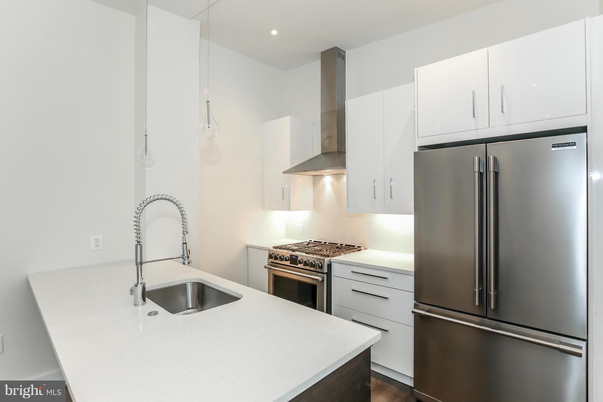 462 Ridge Street Northwest, Unit 3 Washington, DC 20001 - Photo 4 of 20 a kitchen with refrigerator a sink and cabinets