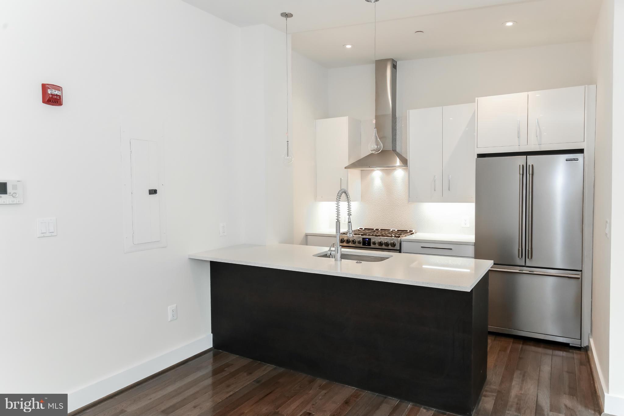 462 Ridge Street Northwest, Unit 3 Washington, DC 20001 - Photo 5 of 20 a kitchen with kitchen island a sink appliances a counter space and a window