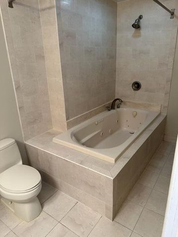 a white bath tub sitting next to a white toilet