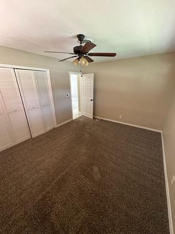 a view of a room with an empty space and a ceiling fan