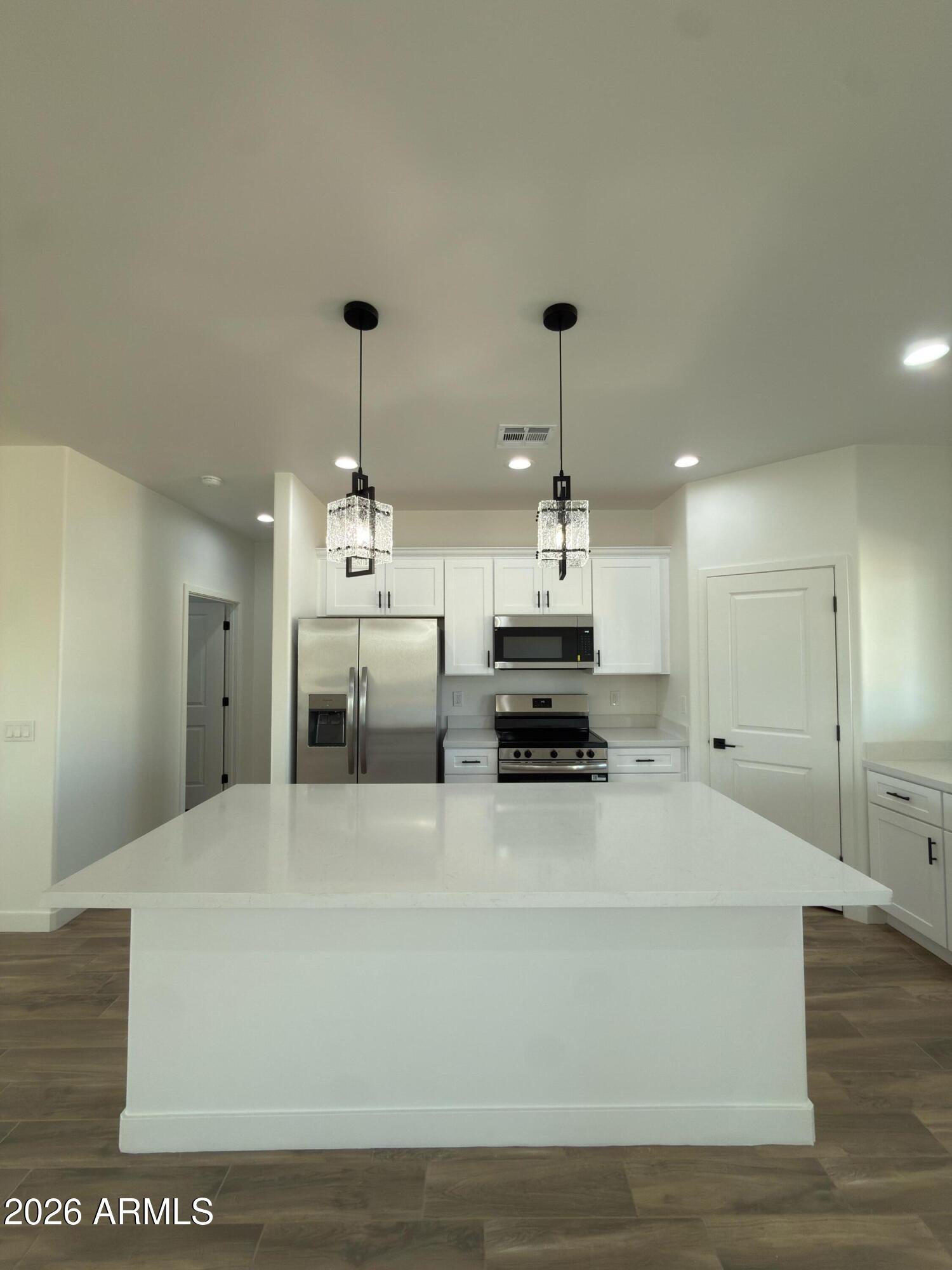 14199 South Diablo Road Arizona City, AZ 85123 - Photo 3 of 18 a large white kitchen with stainless steel appliances