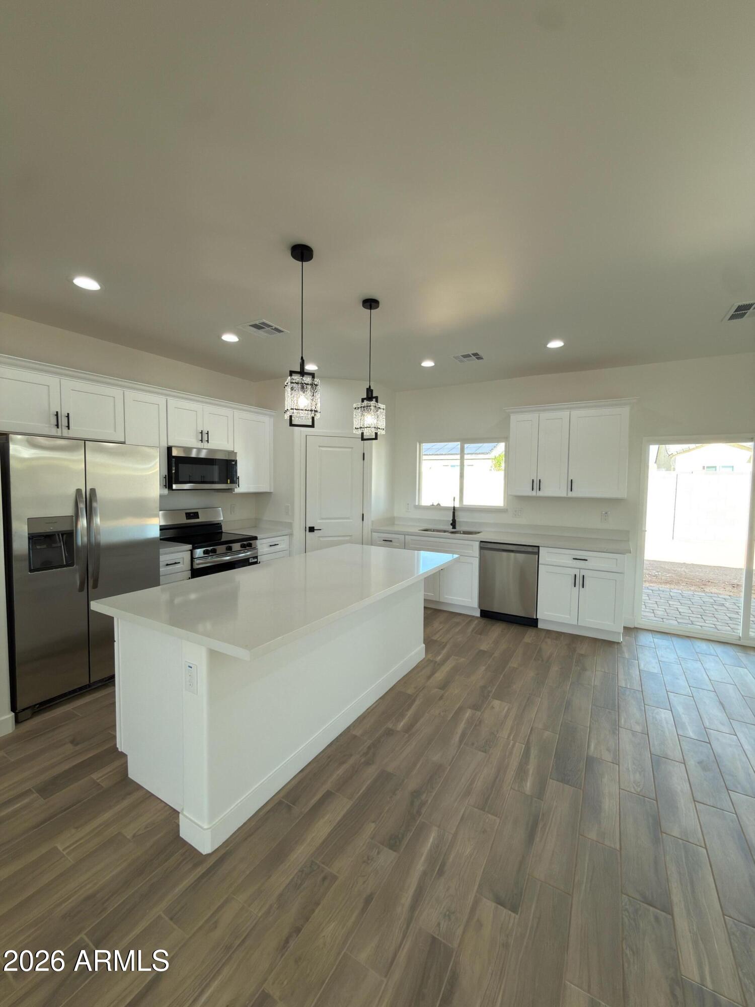 14199 South Diablo Road Arizona City, AZ 85123 - Photo 4 of 18 a large white kitchen with stainless steel appliances