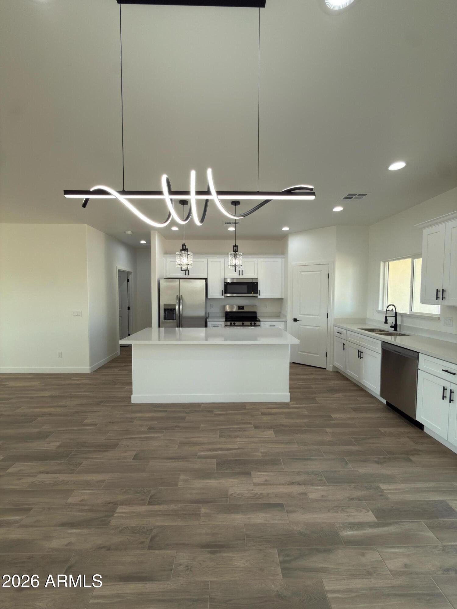 14199 South Diablo Road Arizona City, AZ 85123 - Photo 5 of 18 a large white kitchen with kitchen island a sink stainless steel appliances and cabinets