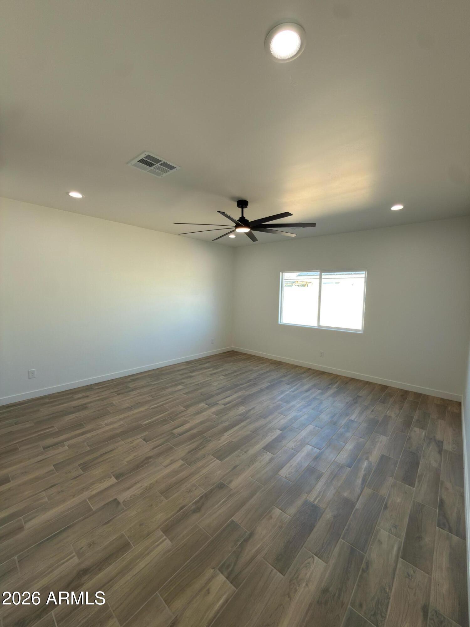 14199 South Diablo Road Arizona City, AZ 85123 - Photo 7 of 18 an empty room with wooden floor and windows