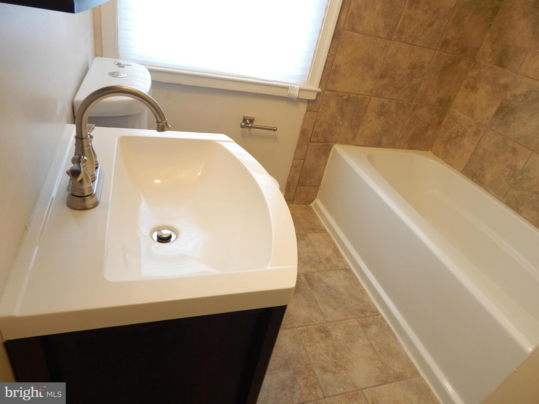 5222 Kelway Road Baltimore, MD 21239 - Photo 8 of 25 a bathroom with a sink and a bathtub