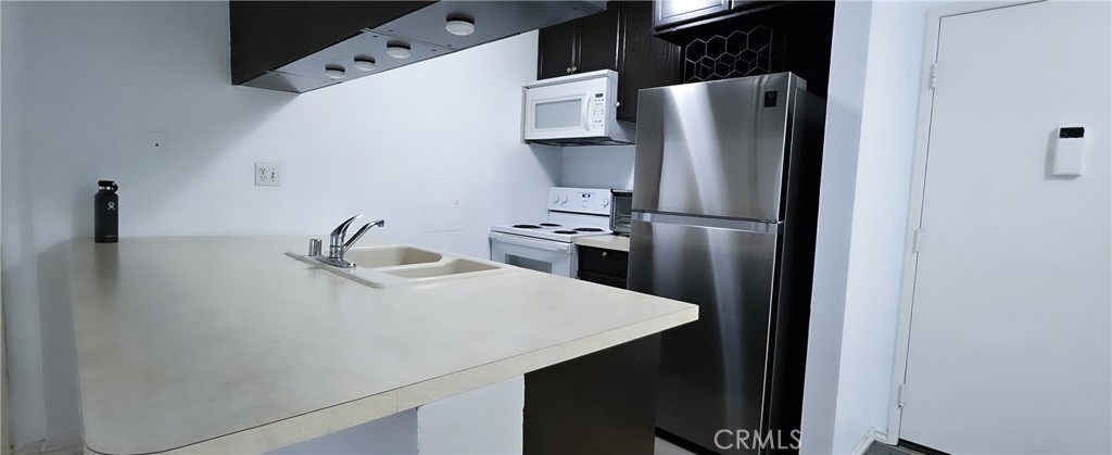 a kitchen with stainless steel appliances a refrigerator and a sink