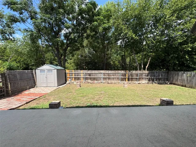 a view of a swimming pool with a yard and large trees