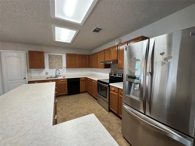 a large kitchen with a large window and stainless steel appliances