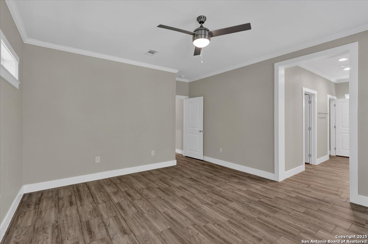 611 Rudolph San Antonio, TX 78202 - Photo 12 of 25 an empty room with wooden floor and ceiling fan