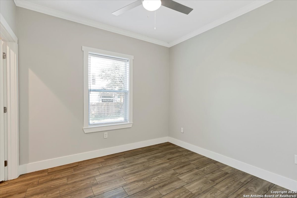 611 Rudolph San Antonio, TX 78202 - Photo 18 of 25 an empty room with wooden floor a ceiling fan and windows