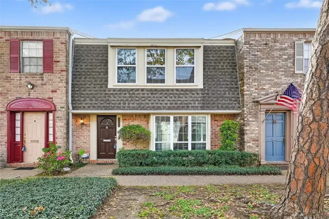 front view of a brick house with a yard