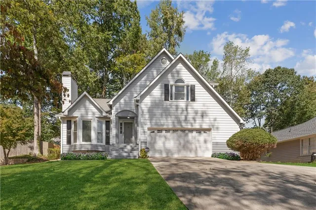 a view of a house with a yard and potted plants