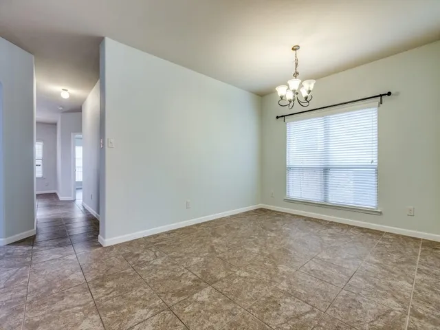 an empty room with chandelier and windows