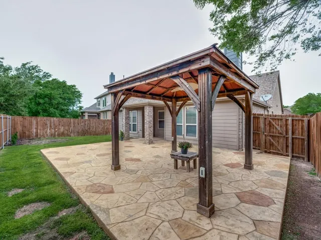 a backyard of a house with barbeque oven and table and chairs