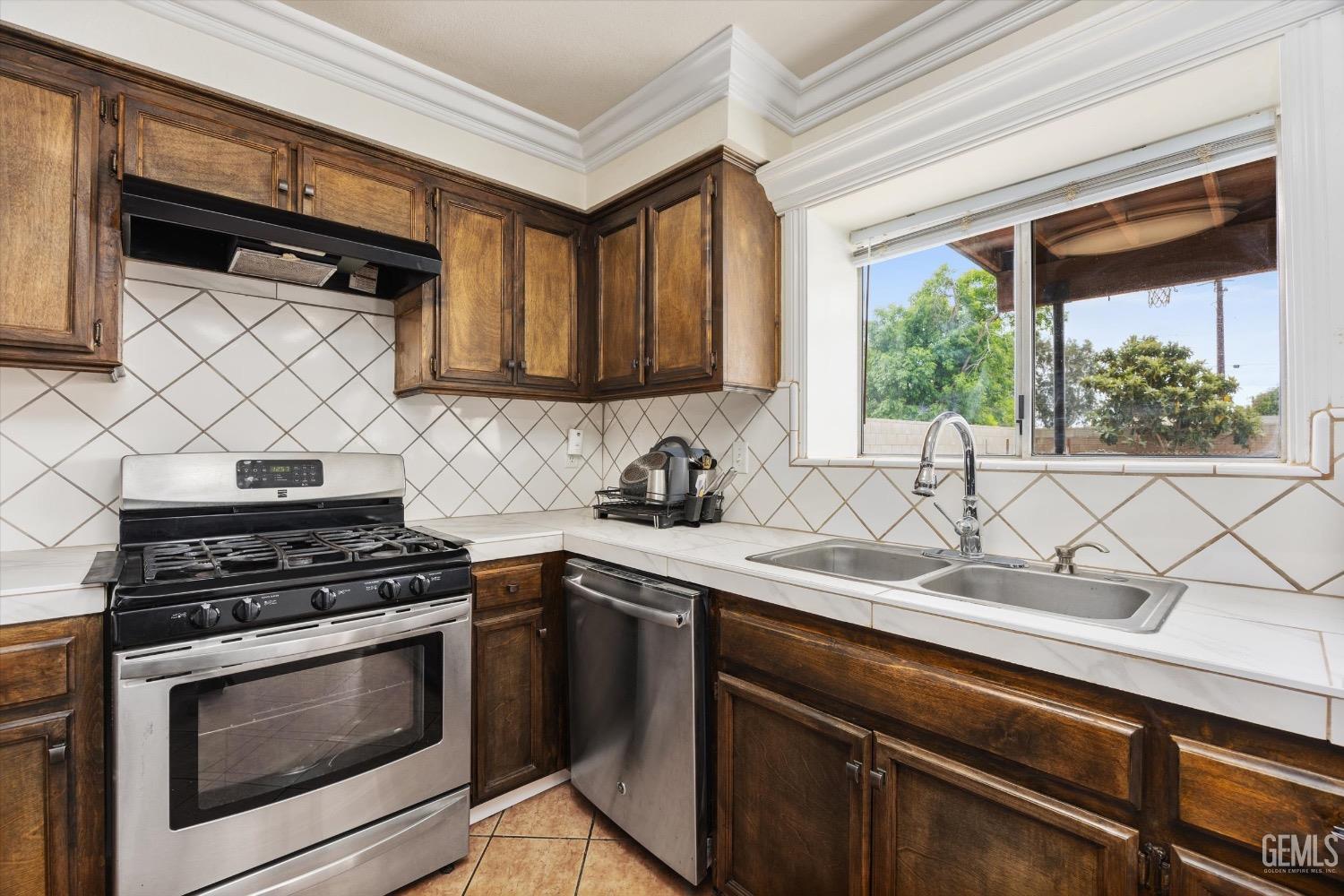 Undisclosed Address Bakersfield, CA 93307 - Photo 18 of 47 a kitchen with stainless steel appliances a stove sink and cabinets