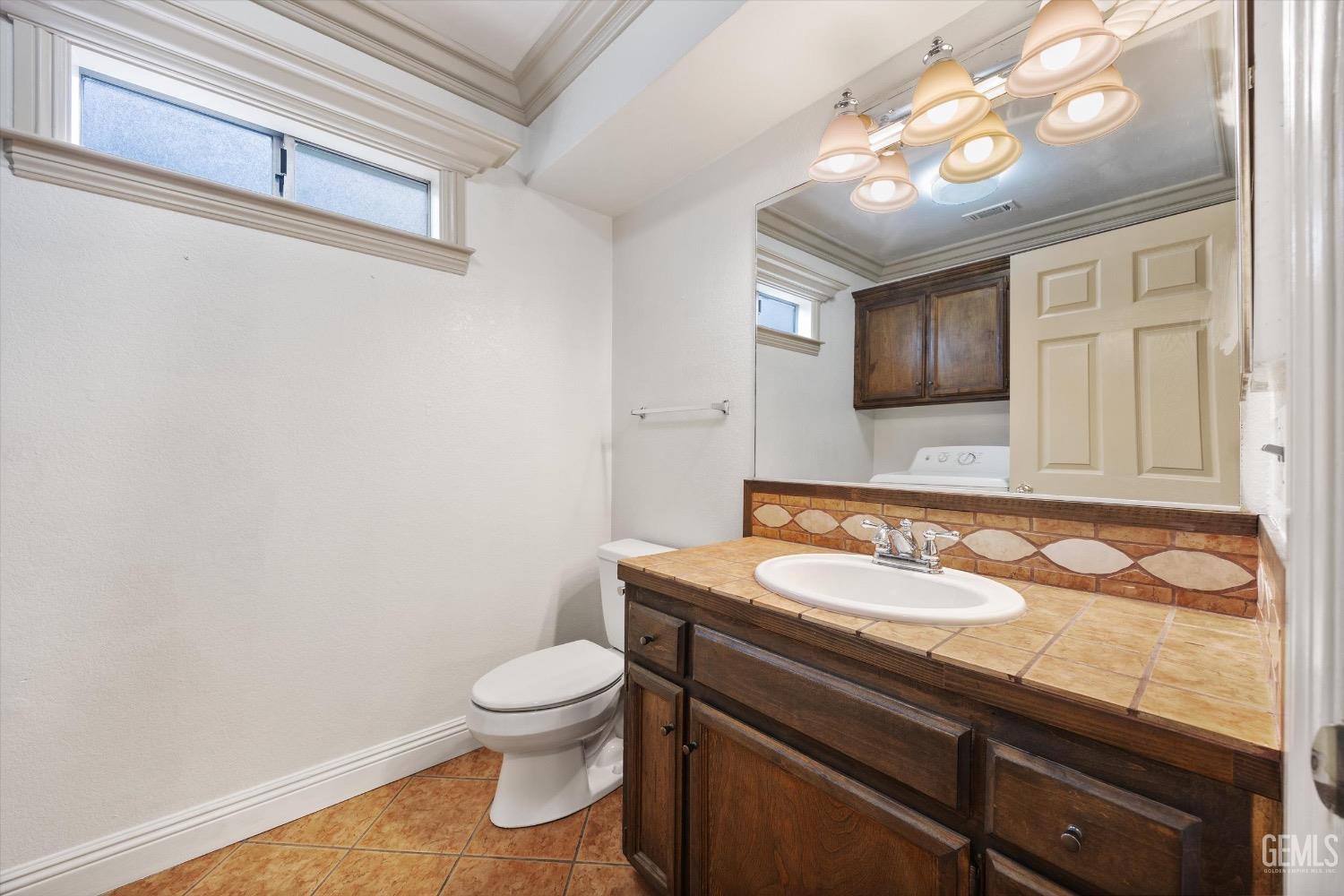 Undisclosed Address Bakersfield, CA 93307 - Photo 21 of 47 a bathroom with a toilet a sink and mirror