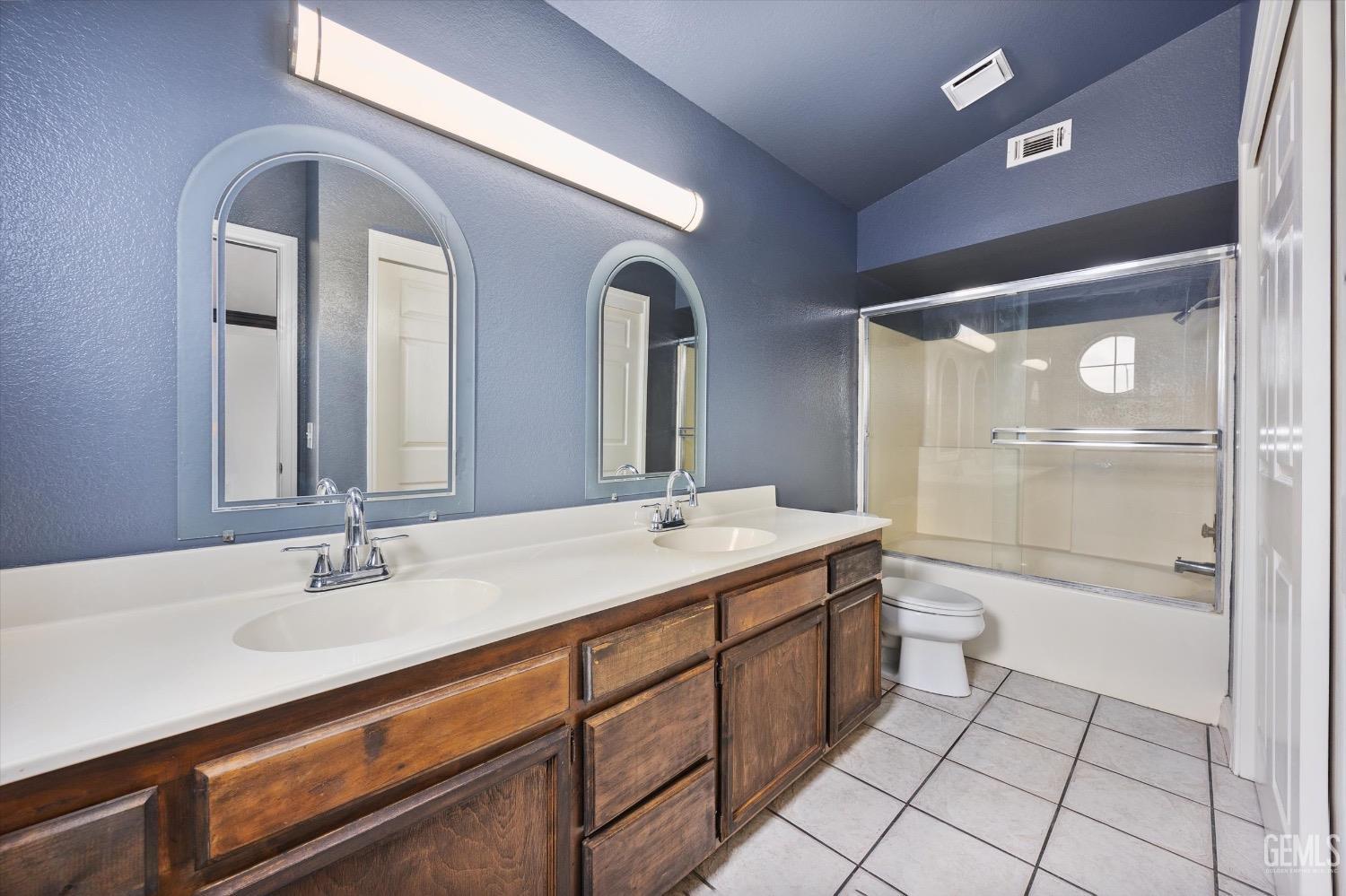 Undisclosed Address Bakersfield, CA 93307 - Photo 26 of 47 a bathroom with a granite countertop sink a toilet a mirror and shower