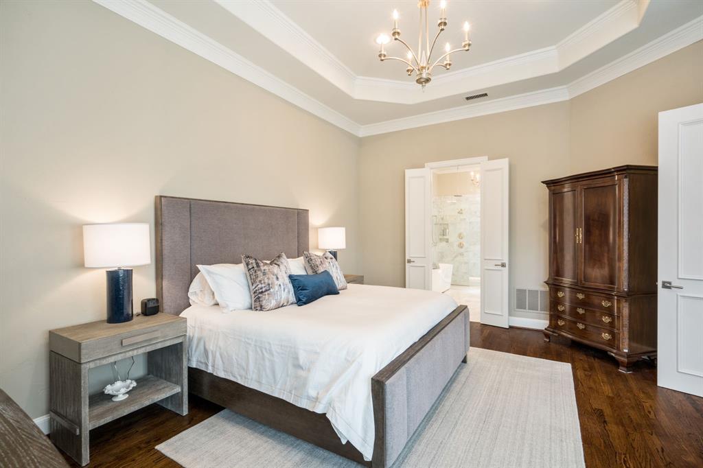 5116 Meadowside Lane Plano, TX 75093 - Photo 16 of 36 a bedroom with a large bed and a chandelier