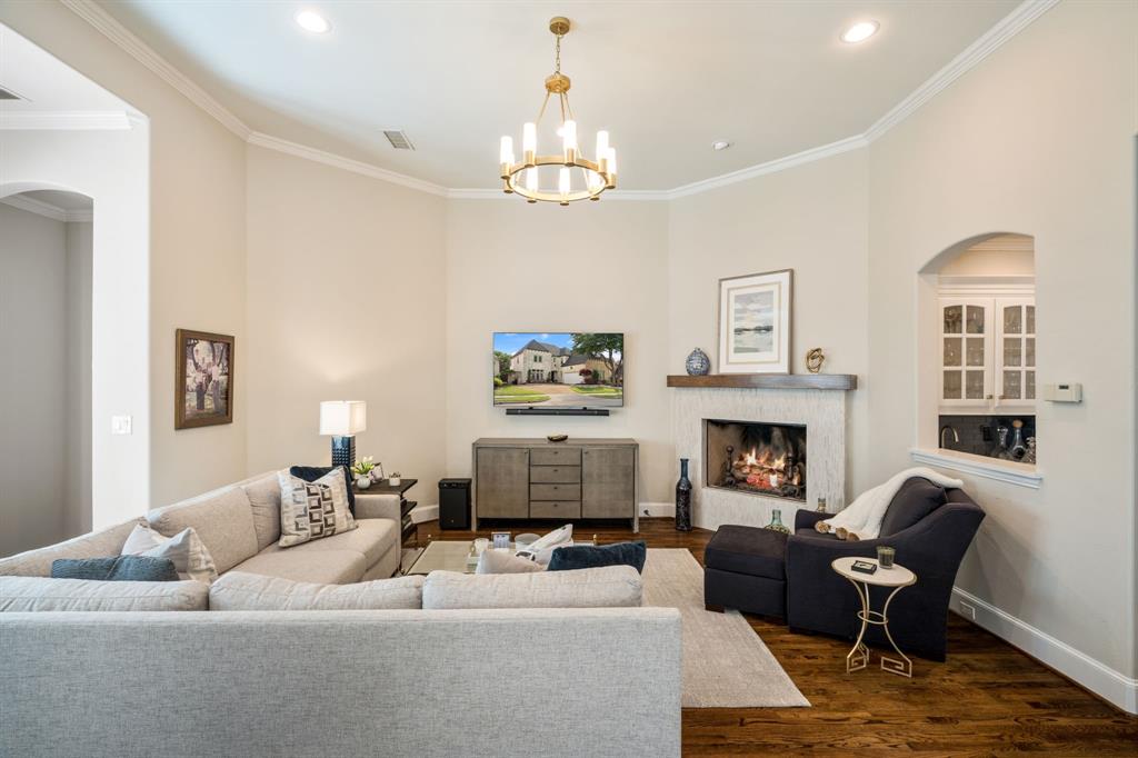 5116 Meadowside Lane Plano, TX 75093 - Photo 5 of 36 a living room with furniture a fireplace and a chandelier