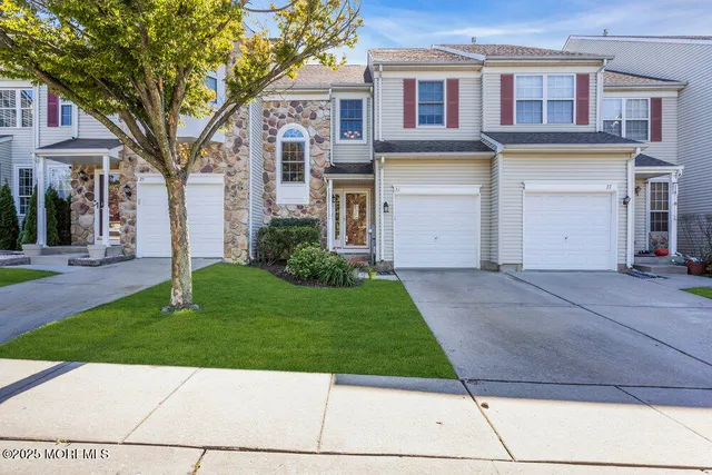 a view of a brick house with a yard and large tree