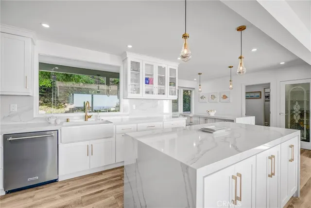 a kitchen with a sink and a stove top oven with wooden floor