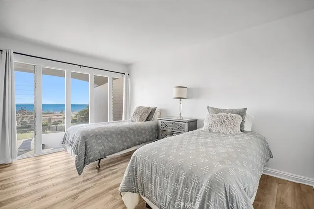 a bedroom with two beds and wooden floor