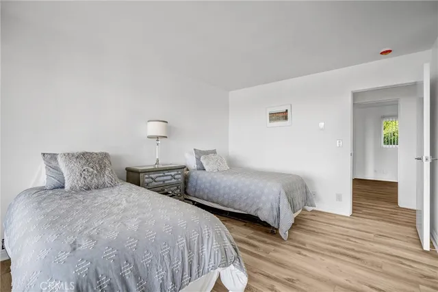 a bedroom with two beds and wooden floor