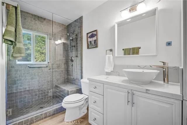 a bathroom with a sink a toilet and shower