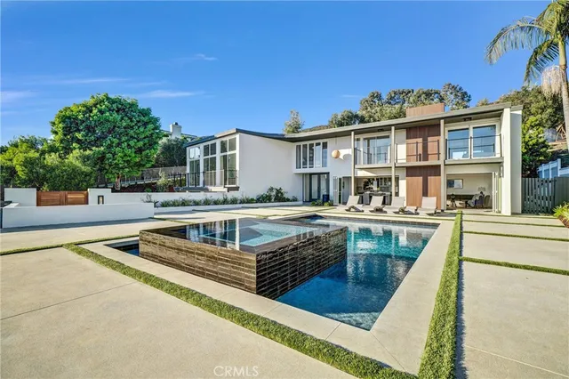 a view of a house with swimming pool and sitting area
