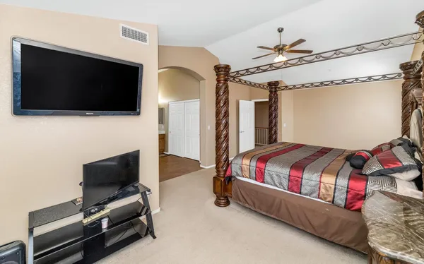 an empty room with wooden floor chandelier and windows